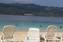 White beach chairs beach waters and a resort in the disatance from Cayo Levantado.jpg