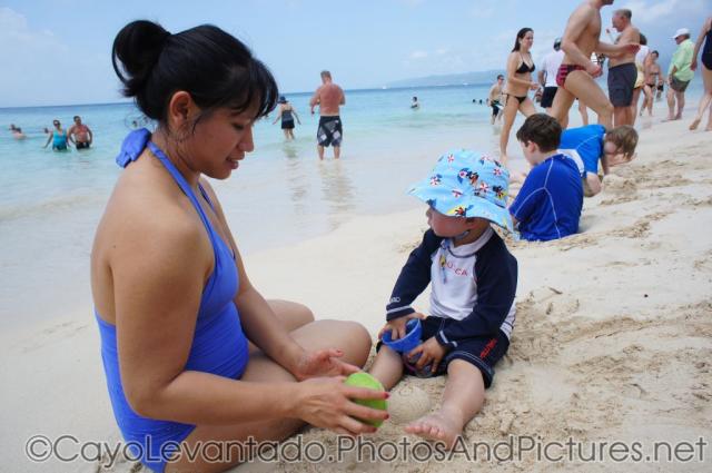 Darwin and mommy sit at the Cayo Levantado beach sand.jpg