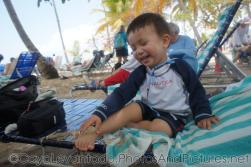 Darwin smiles as he tries to get sand off his foot while on a beach chair at Cayo Levantado.jpg