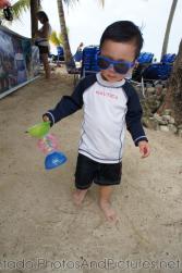 Darwin in sunglasses holds a toy at Cayo Levantado beach.jpg