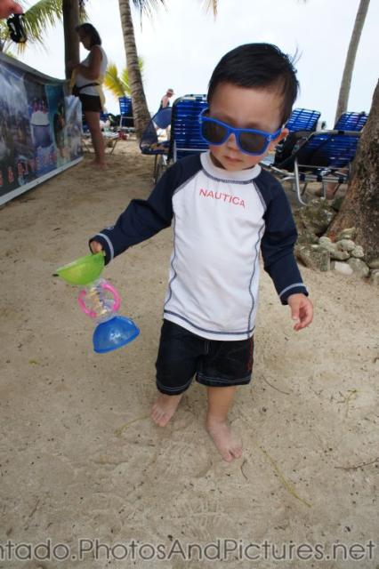 Darwin in sunglasses holds a toy at Cayo Levantado beach.jpg